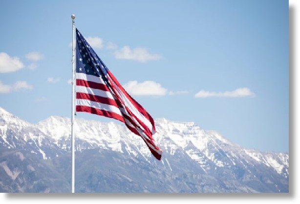 US flag waiving in front of snowy mountains