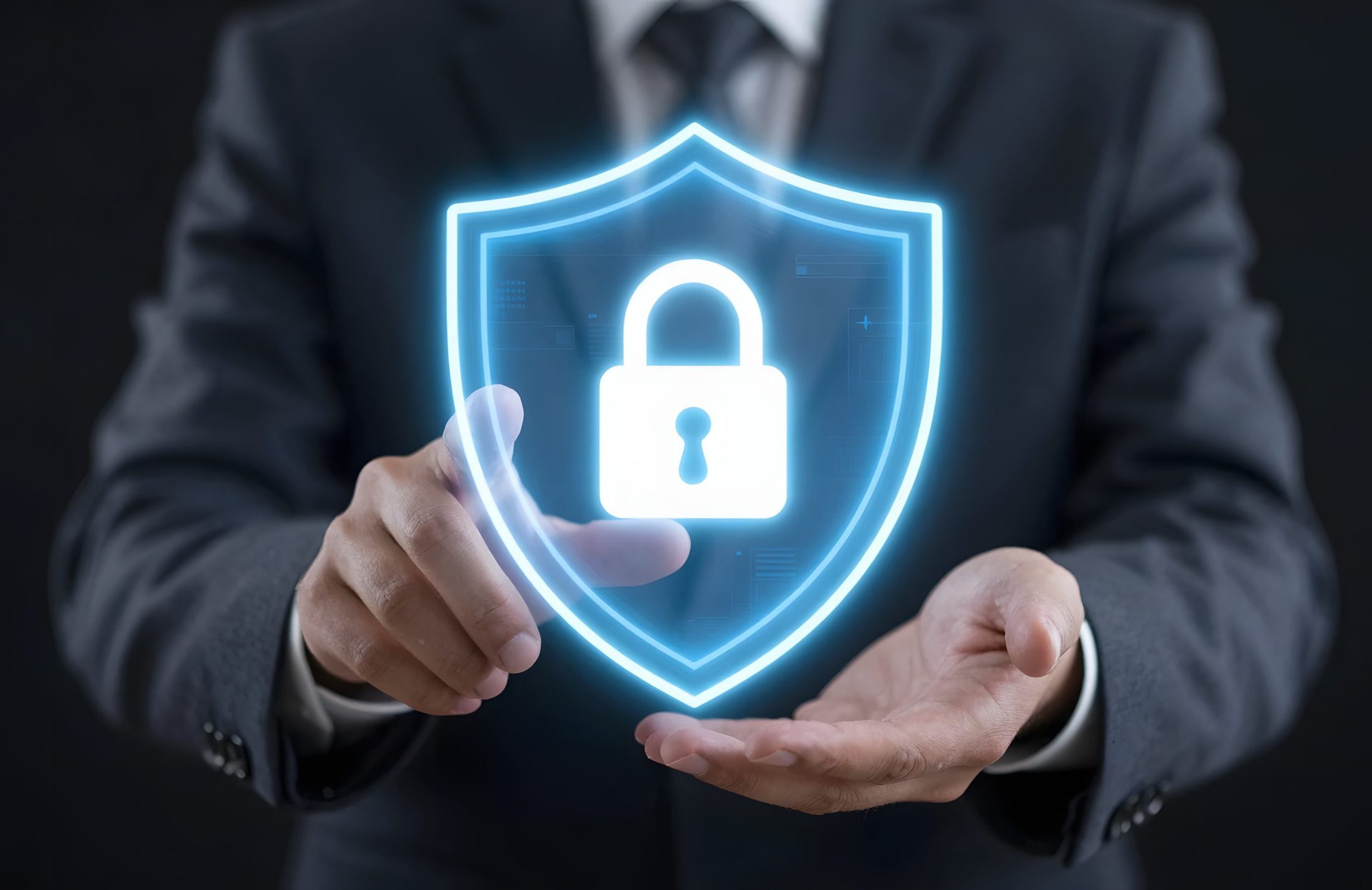A pair of hands holding a glowing blue shield with a padlock icon.