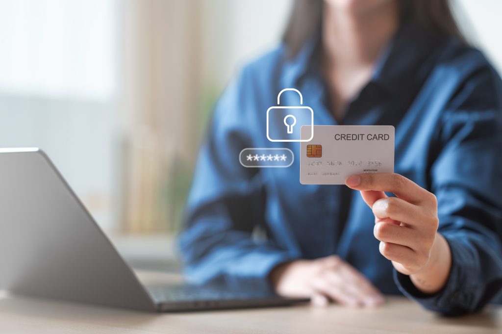 A person holding a credit card with security icons displayed.