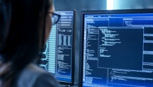 a woman sitting in front of a computer screen with code written on it